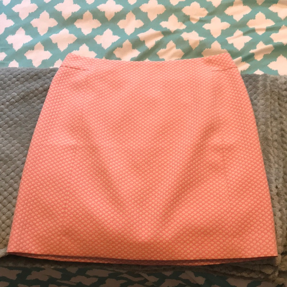 a pink/salmon pencil skirt with slight polka dots